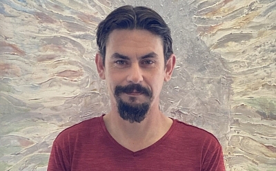 Rhett in front of a painted artwork