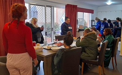 People gathered around a table serving and eating breakfast together
