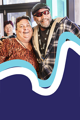 Two people hugging each other smiling on camera